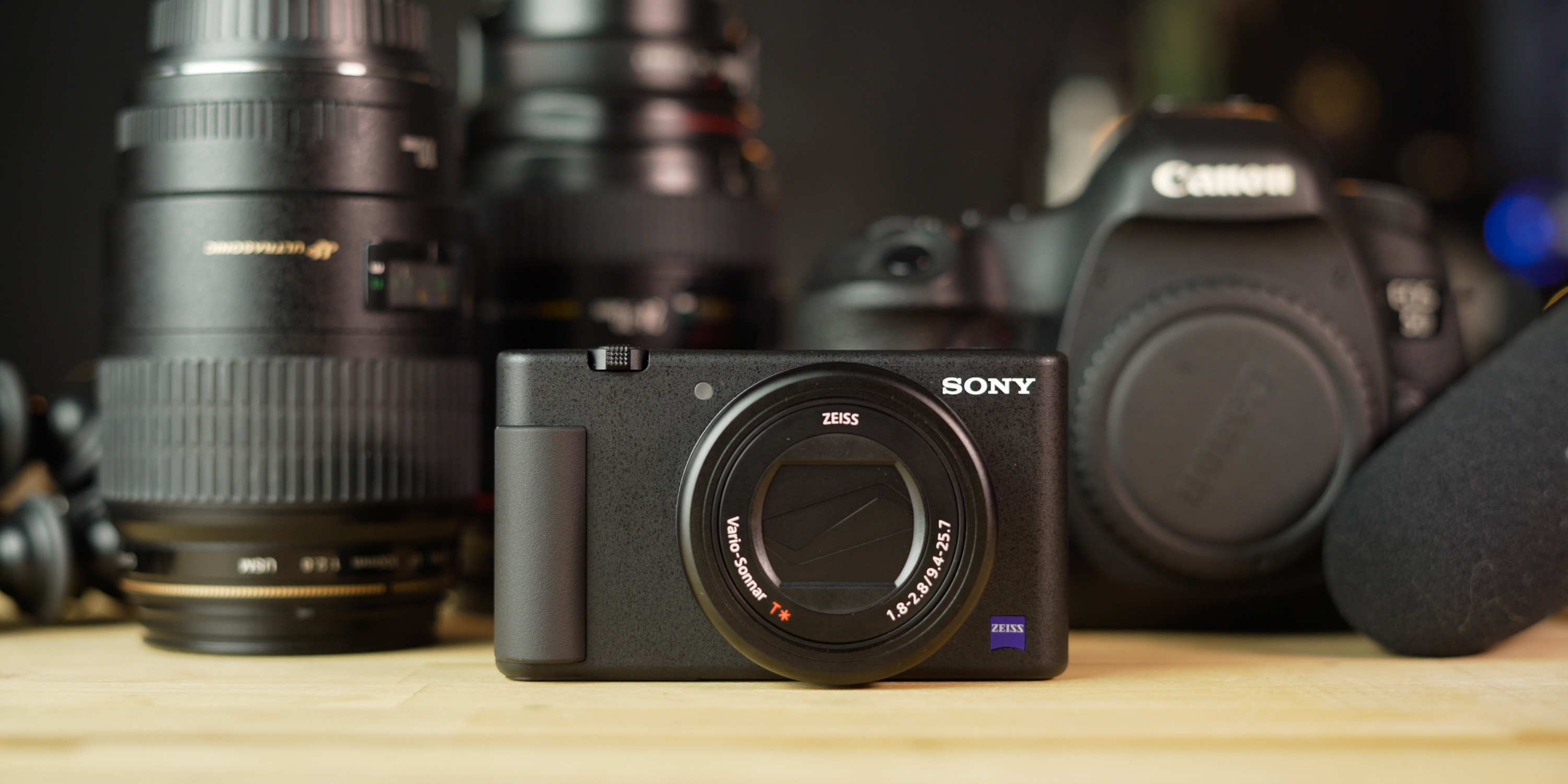 Sony ZV-1 sitting in front of other larger cameras and accessories