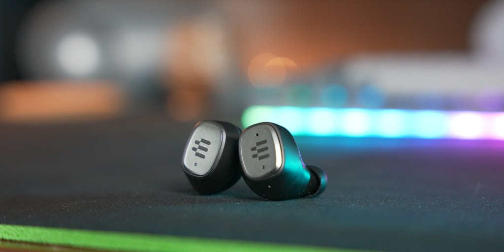 The earbuds have a simple design with a single tactile button on the left earbud.