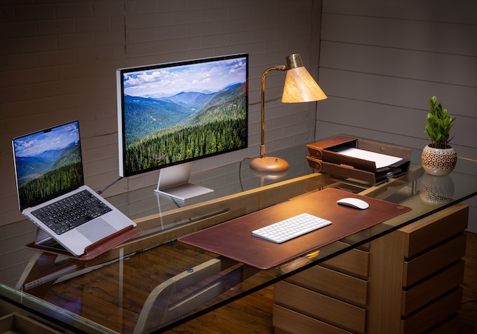 a desk with a laptop computer sitting on top of a wooden table