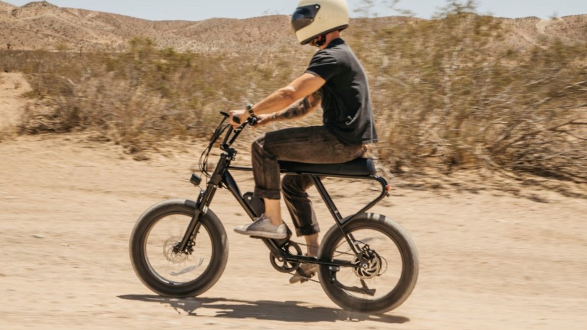 a man riding a bike down a dirt road