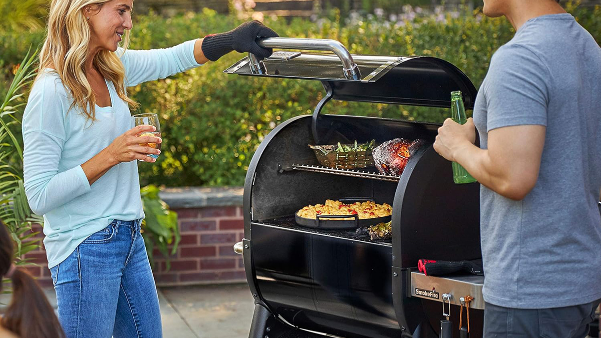 a man and a woman standing on a grill