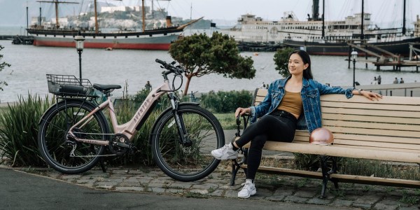 a woman sitting on a bench next to a bicycle