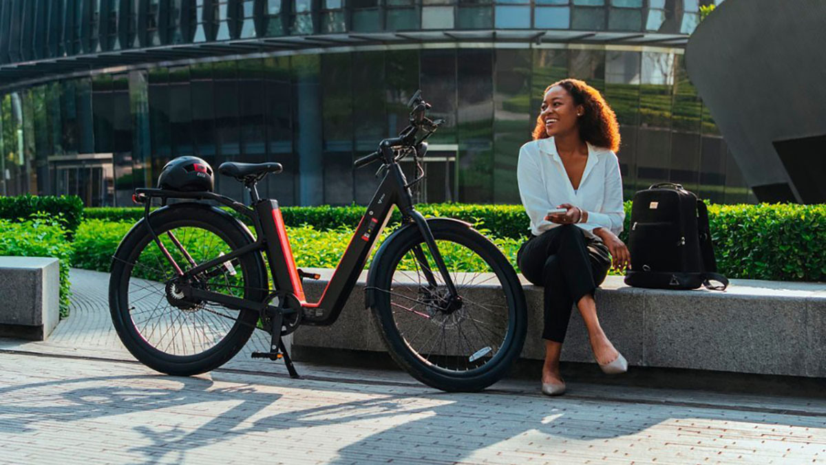 a person sitting on a bench next to a bicycle