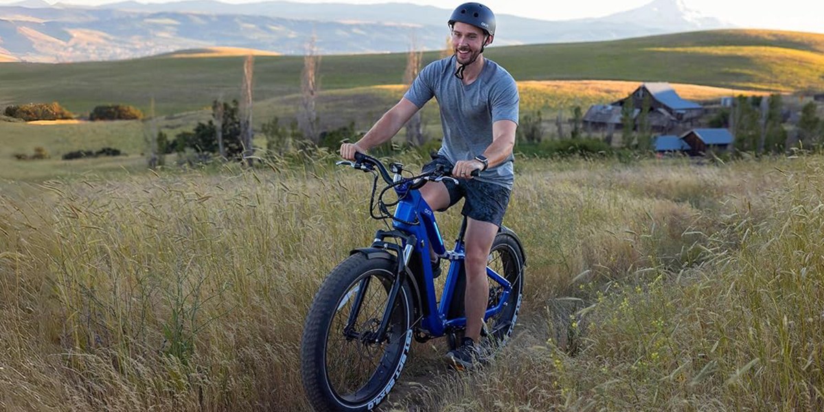 a man riding a bike down a dirt road