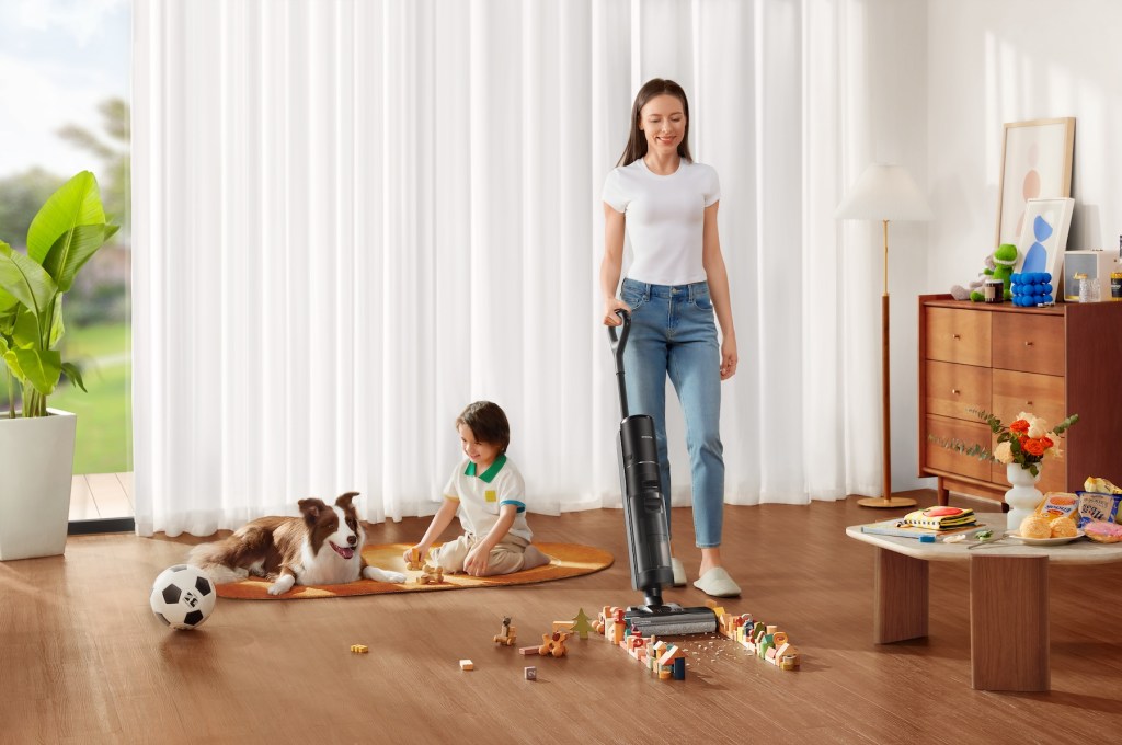 a person and a child playing with toys in a living room