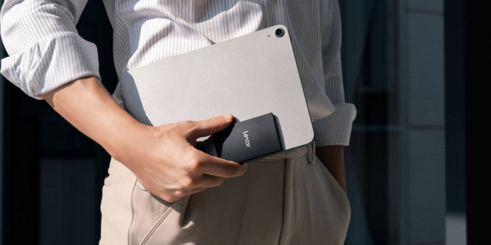 An image showing a person hold the Lexar SL500 SSD with an iPad.
