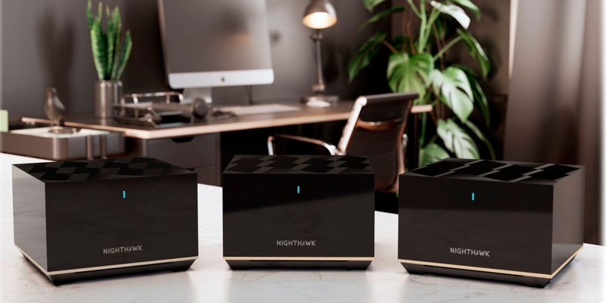 Netgear NIGHTHAWK MK93S mesh router nodes on a desk.