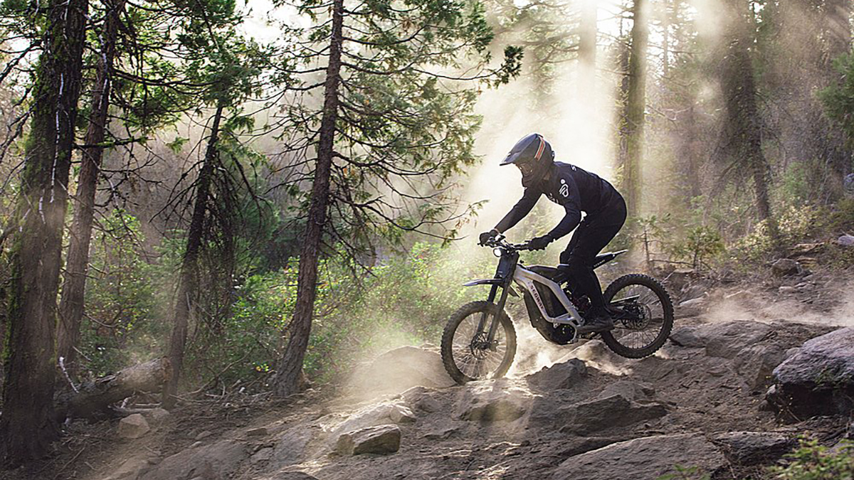 a person riding a bike on a dirt trail in the woods