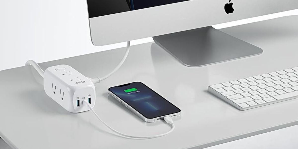 Image showing Anker's 9-in-1 power strip on a desk charging an iPhone.