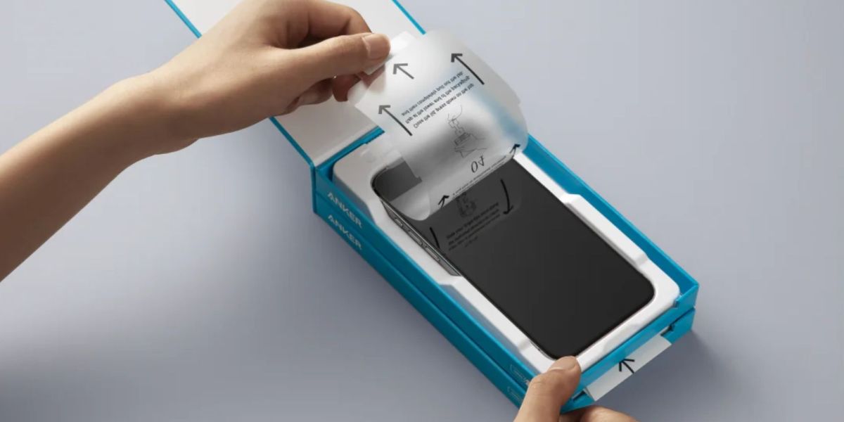 Image showing a person installing a screen protector on their phone using an installation kit.