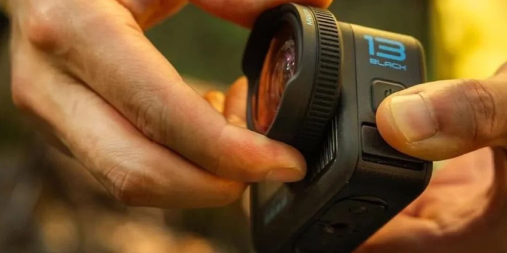 Image showing a person mounting lens on GoPro's HERO13 Black action camera.