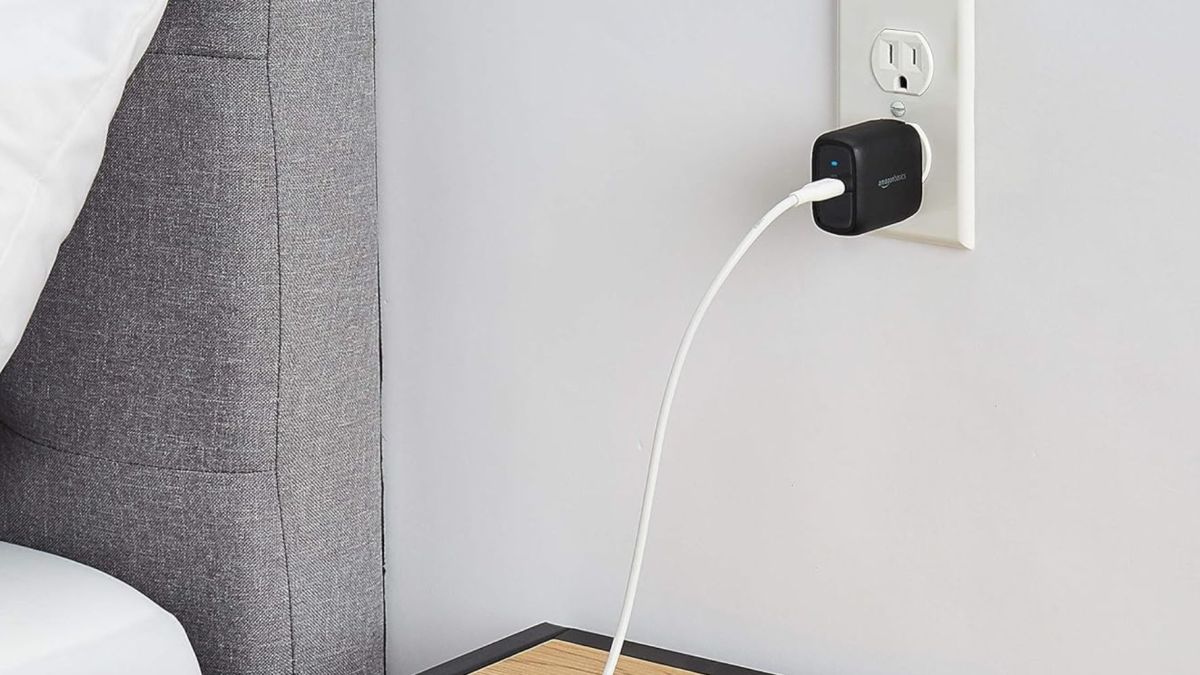 Image showing Amazon's 30W USB-C wall charger powering a device on a bedside table.