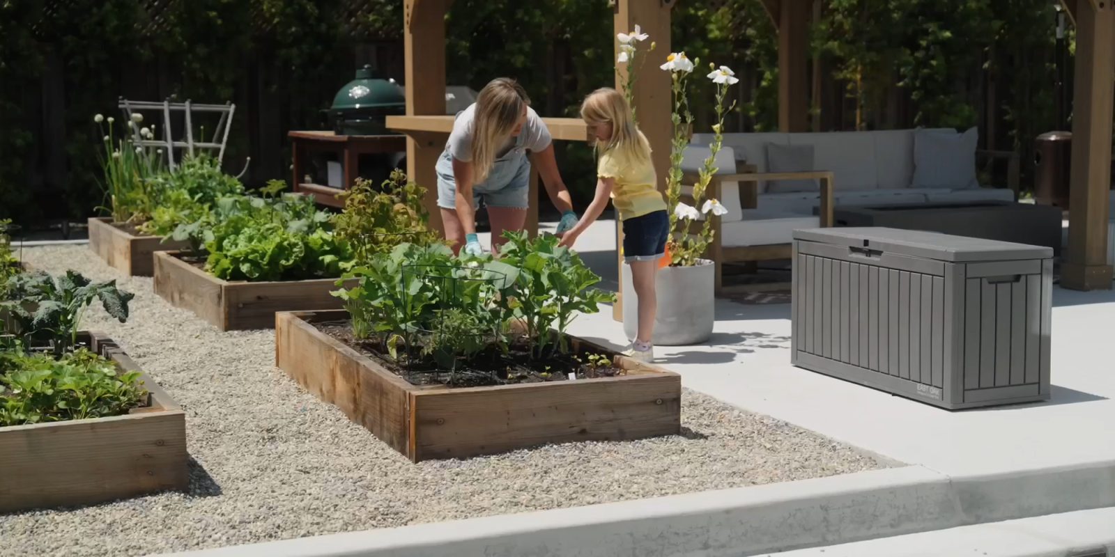 A woman and a girl planting plants in a garden
