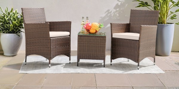 A wicker chairs and a glass table with fruit on it