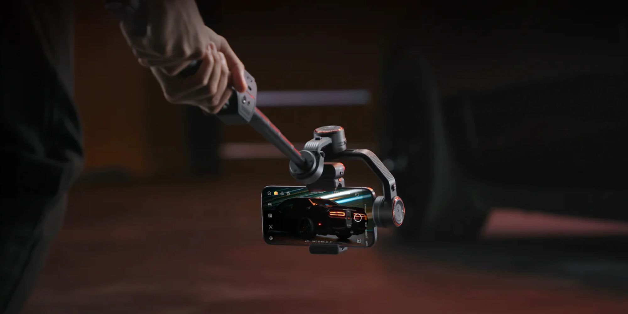 A hand holding a phone with a selfie stick