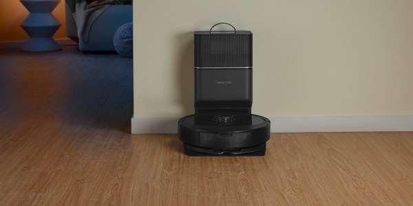 A black robot vacuum cleaner on a wood floor