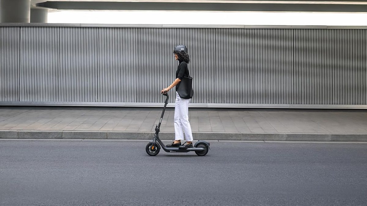 A woman riding a scooter