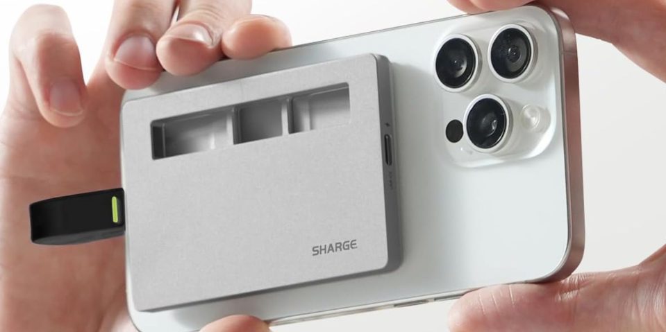Image showing a person holding Sharge's Disk Plus SSD enclosure attached to a white iPhone.