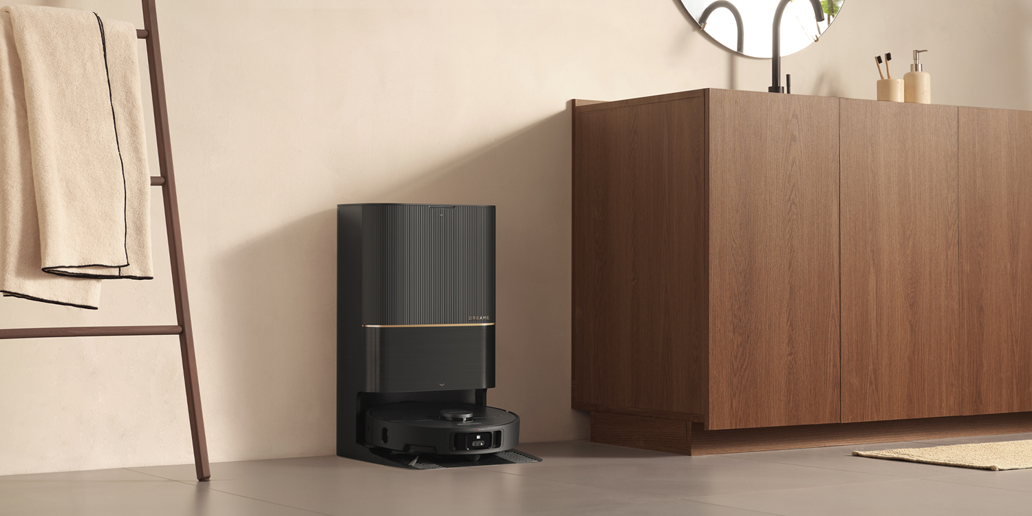 A robot vacuum cleaner next to a cabinet