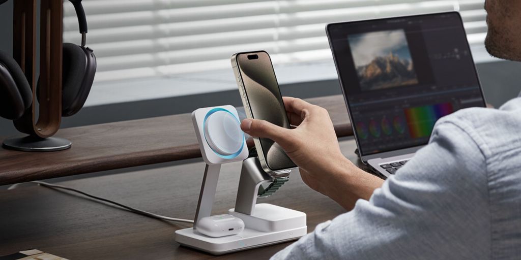 A person holding a phone in front of a charging station.