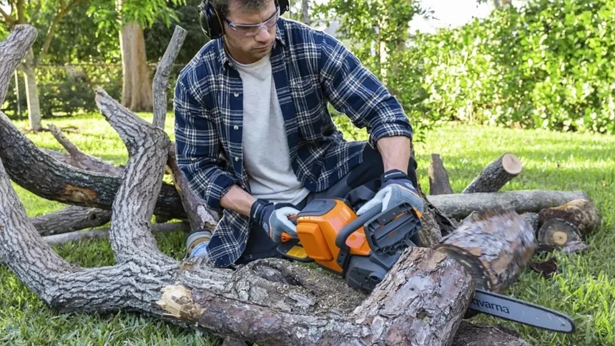A man with headphones and a chainsaw