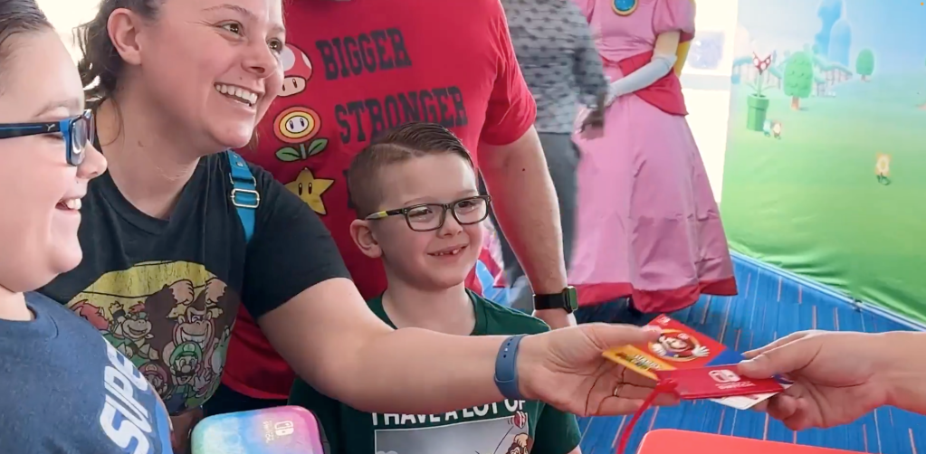 A boy sitting in a chair with a woman in a red shirt