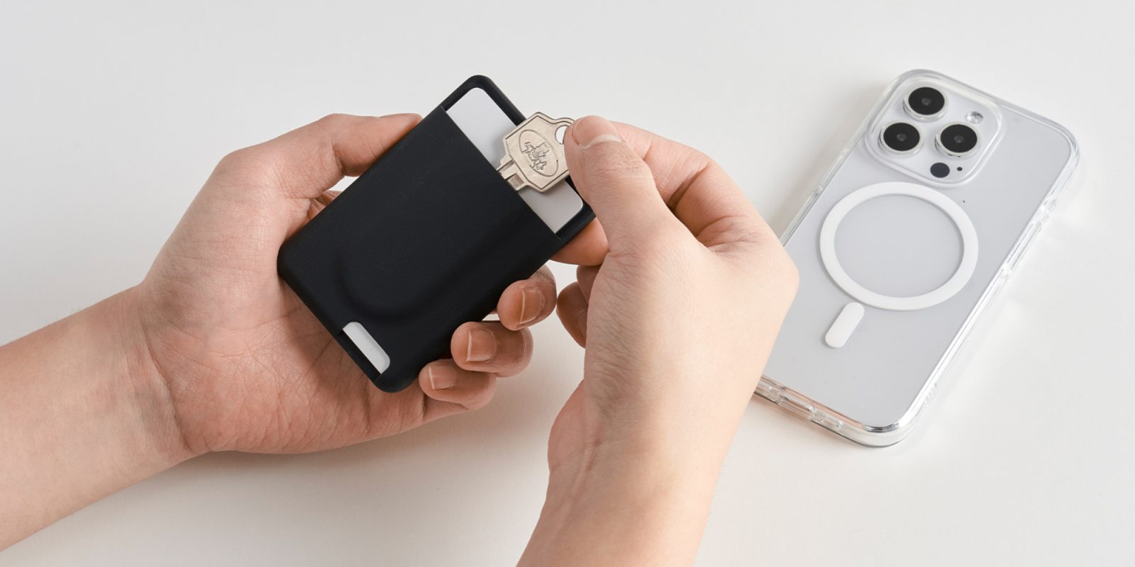 A person holding a key in a black case