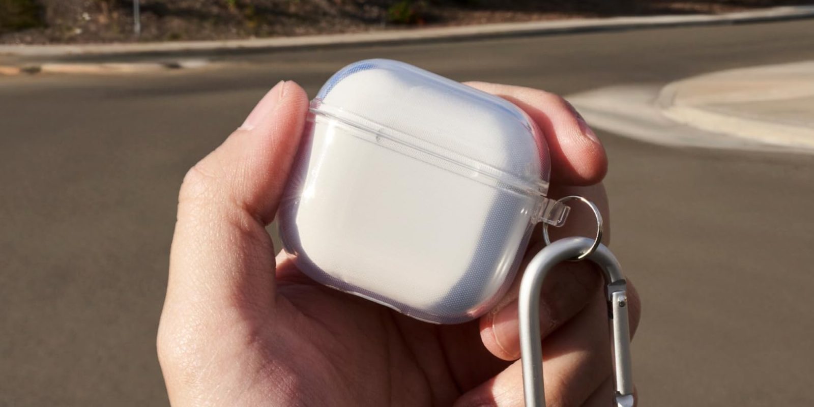 A hand holding a white case