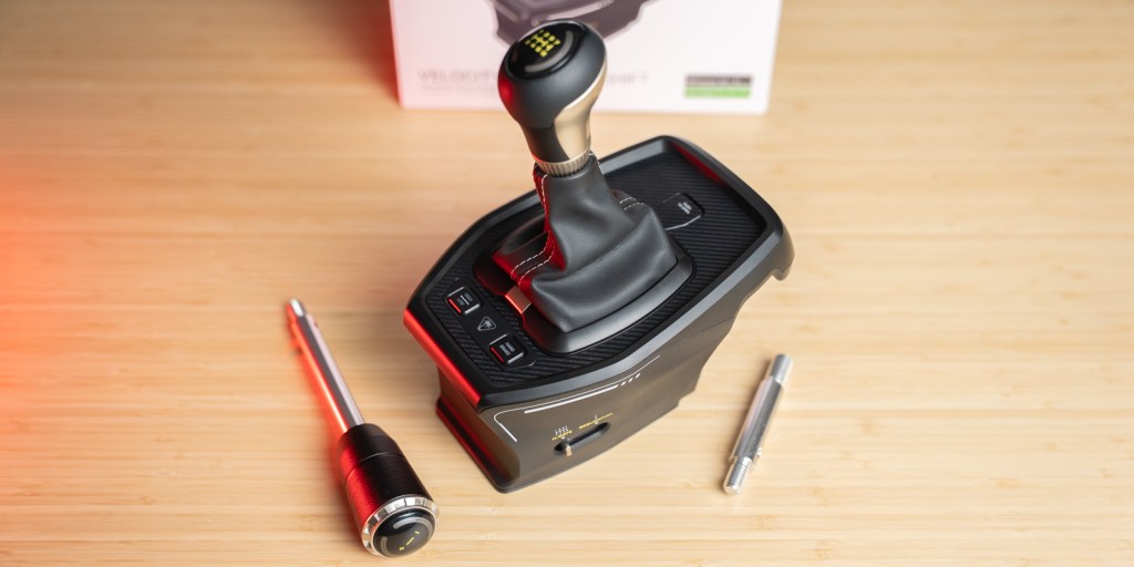 A black gear stick with a silver knob on a wooden surface