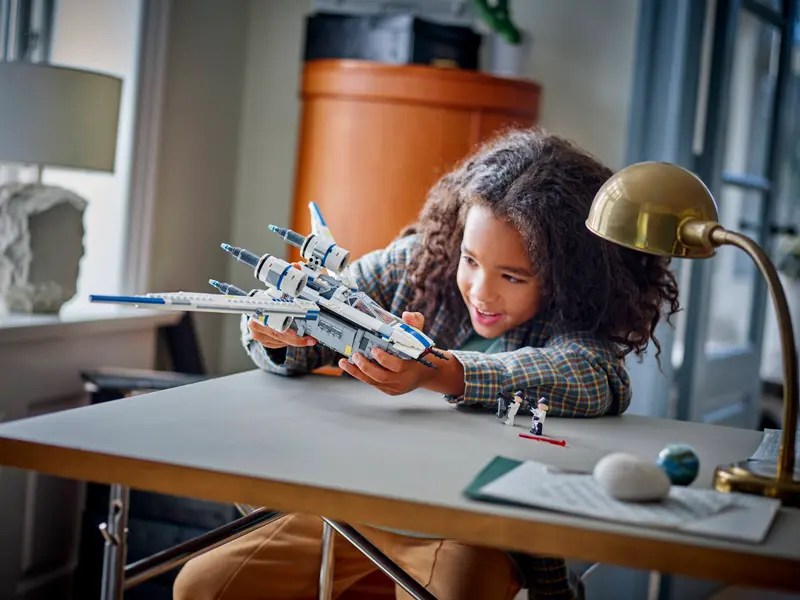 A girl playing with a toy plane