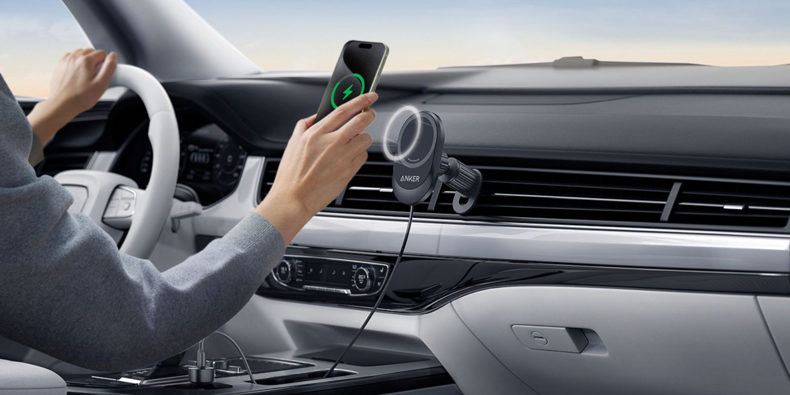 Image showing a person charging their phone with Anker's 15W Qi2 car charger.