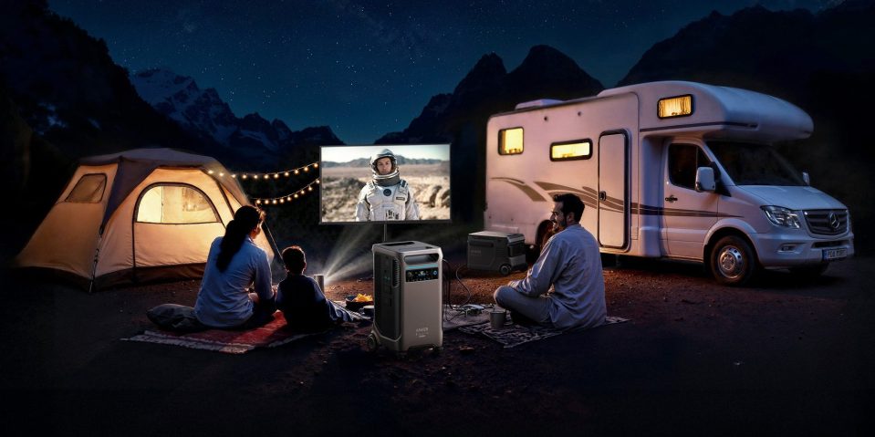 A group of people sitting outside watching a television