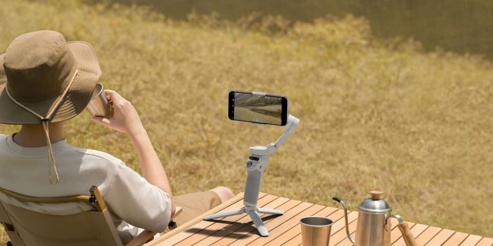 A man sitting at a table with a cell phone on it