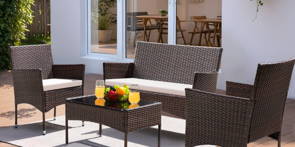 A wicker furniture outside with a basket of fruit on a table