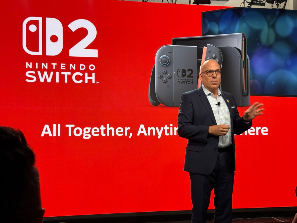 A man standing in front of a large screen