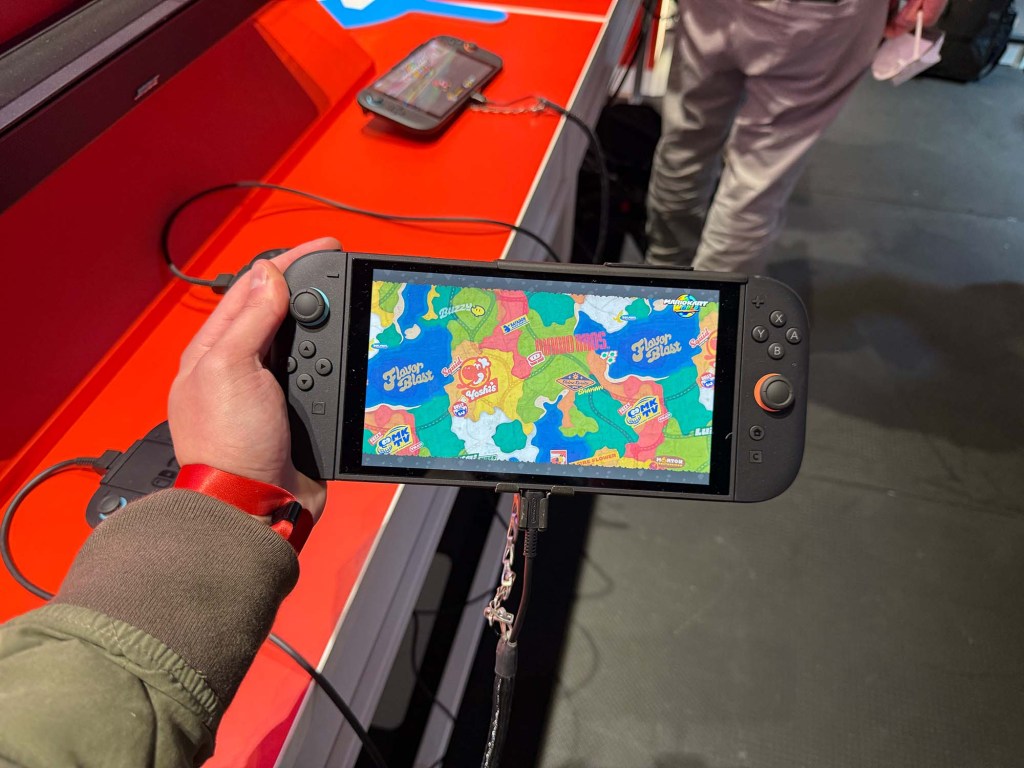 A hand holding a handheld video game device