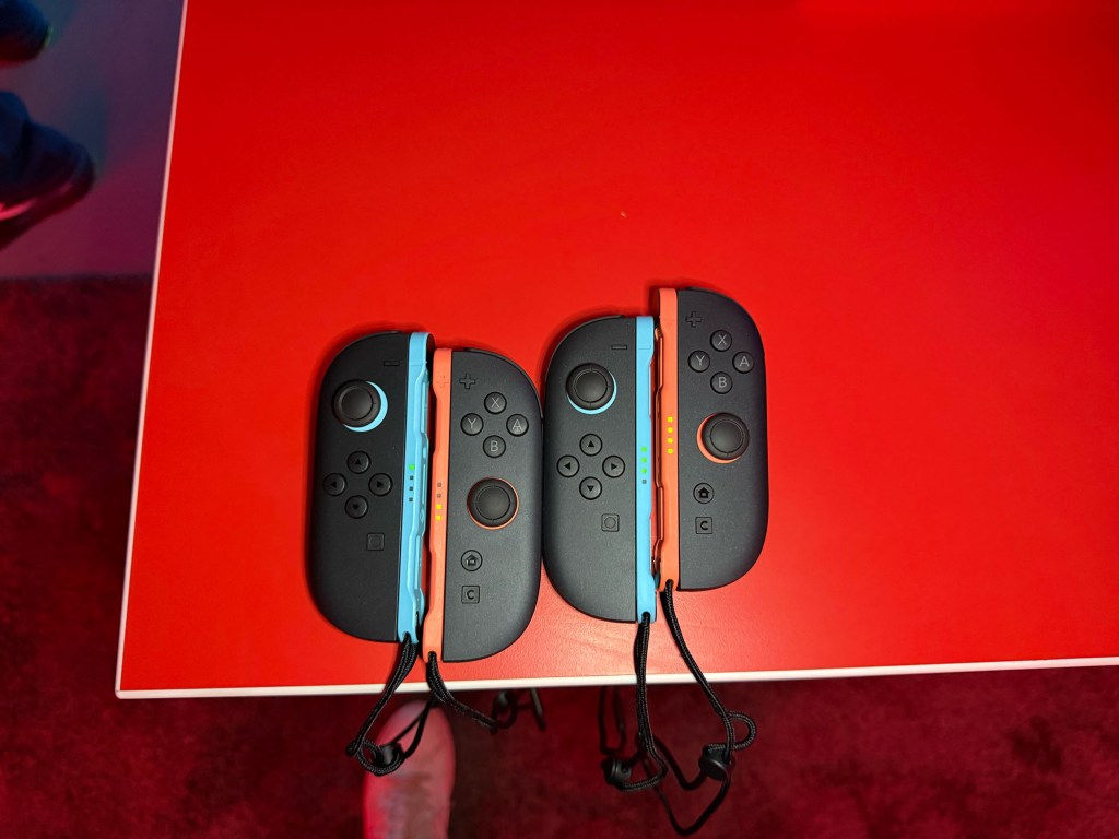 A group of gaming controllers on a red table