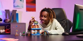 A boy sitting at a desk with toys