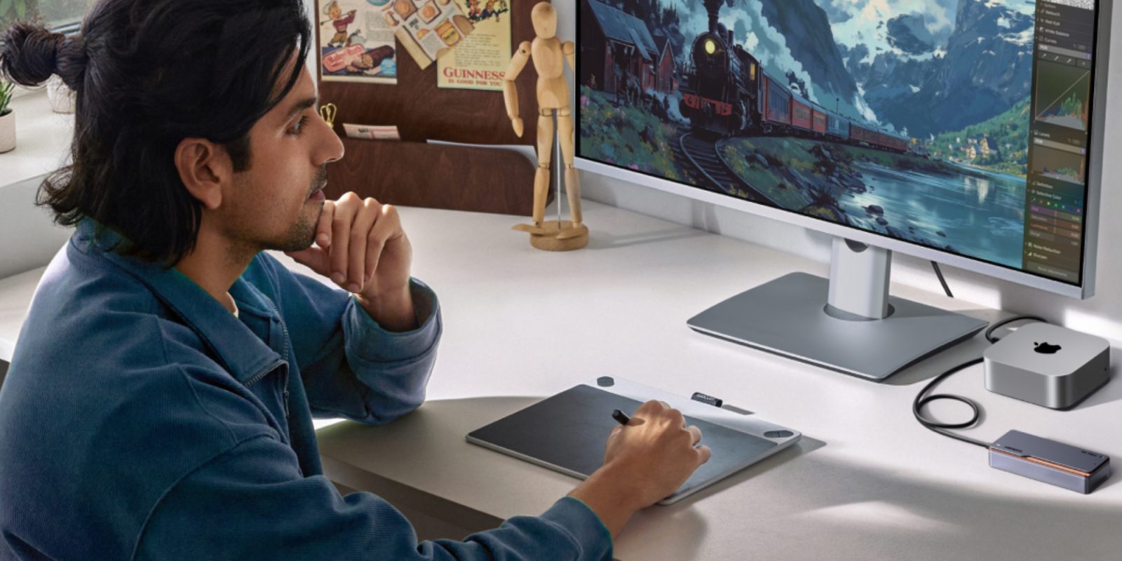 A man sitting at a desk with a computer and a tablet
