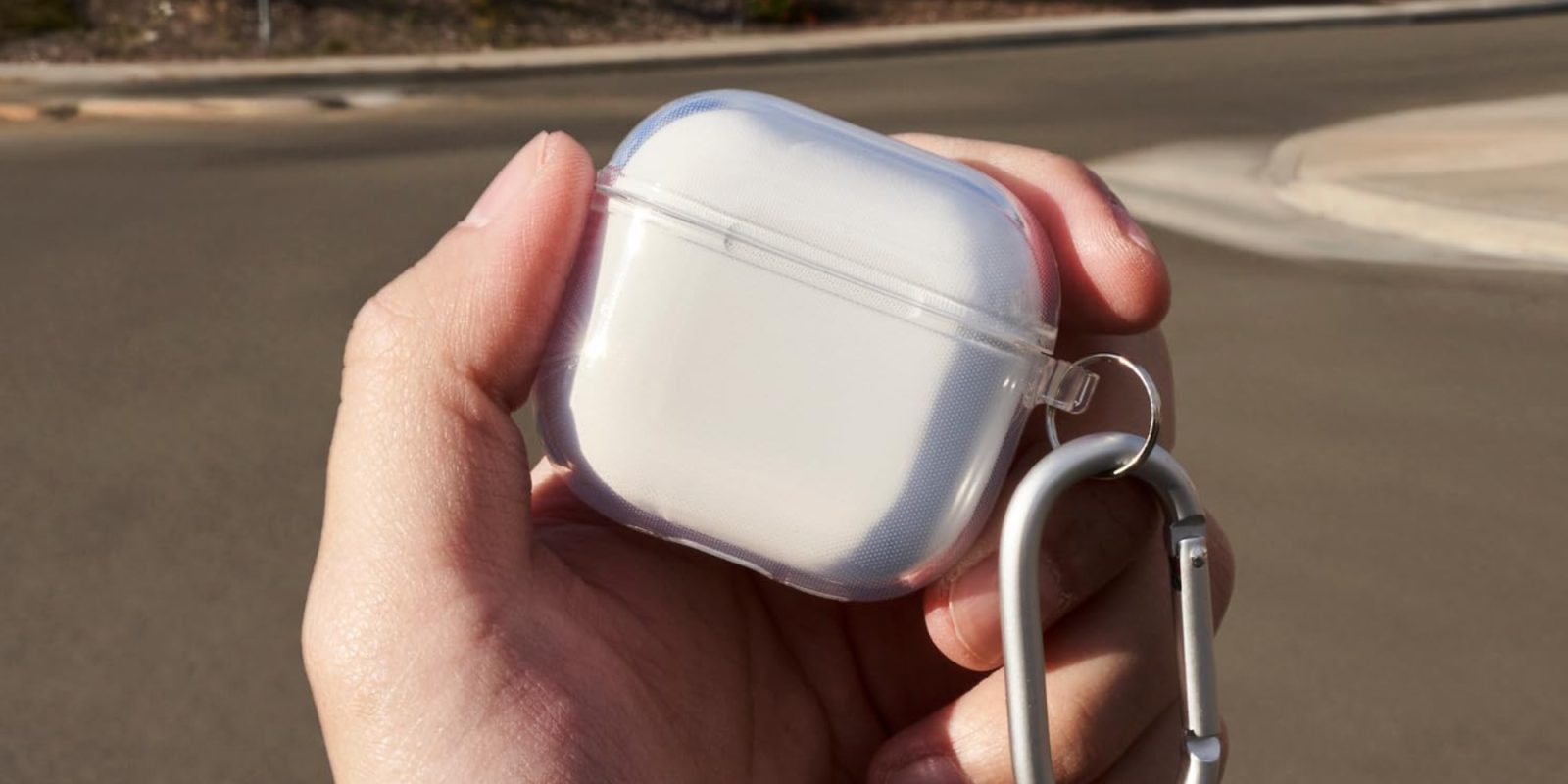 A hand holding a white case