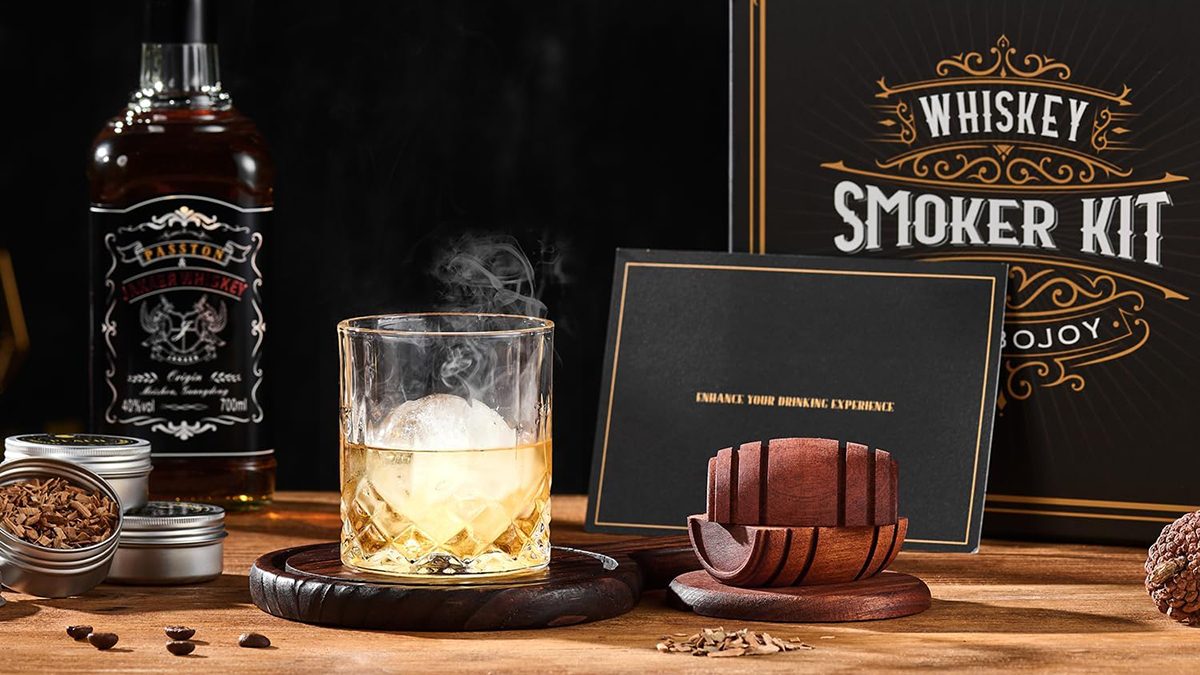 A glass of whiskey with ice and smoke