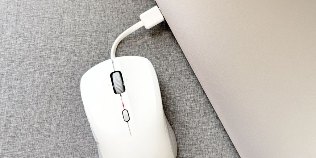 A white computer mouse with a cord