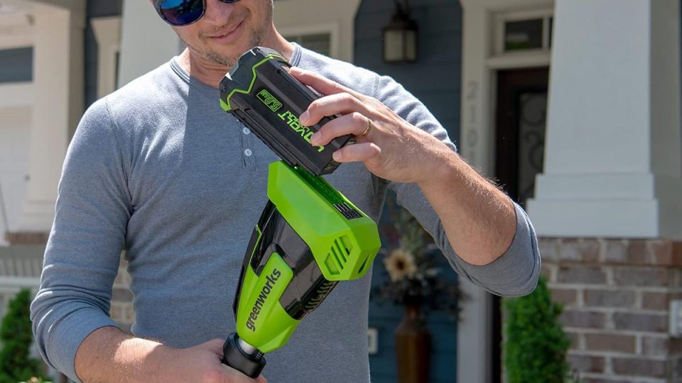 A man holding a green and black power tool