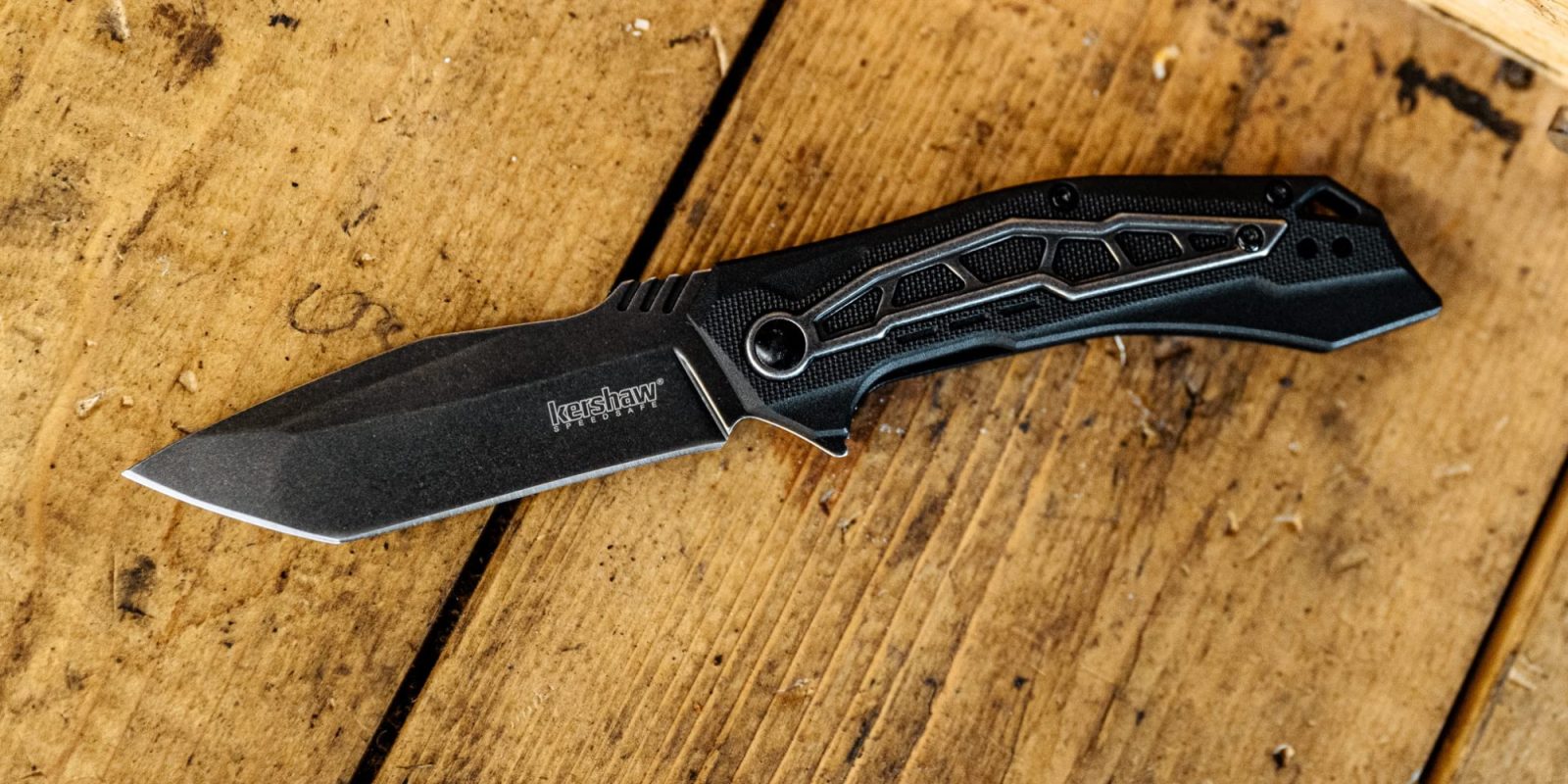 A black knife on a wooden surface