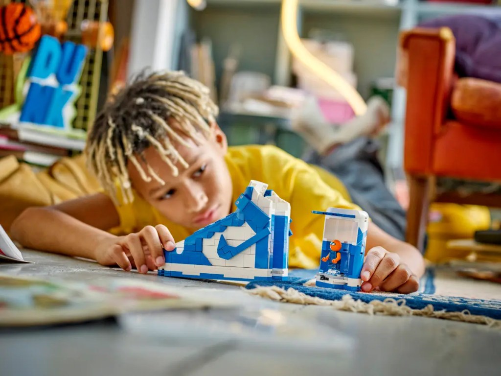 A boy playing with LEGO Nike Dunk set