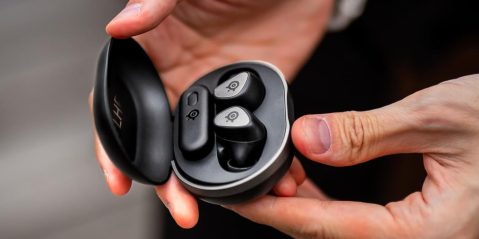 A person holding a black box with a pair of hands