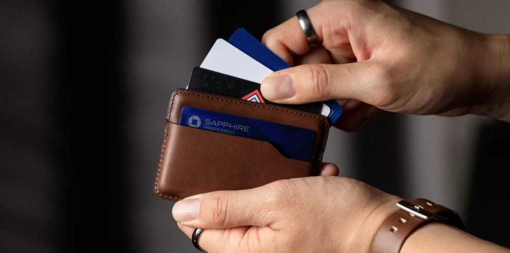 A person holding a wallet with credit cards