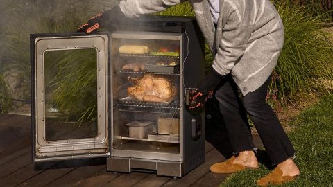 A man putting food into an open oven