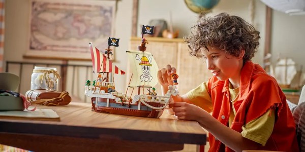 A boy playing with a toy ship