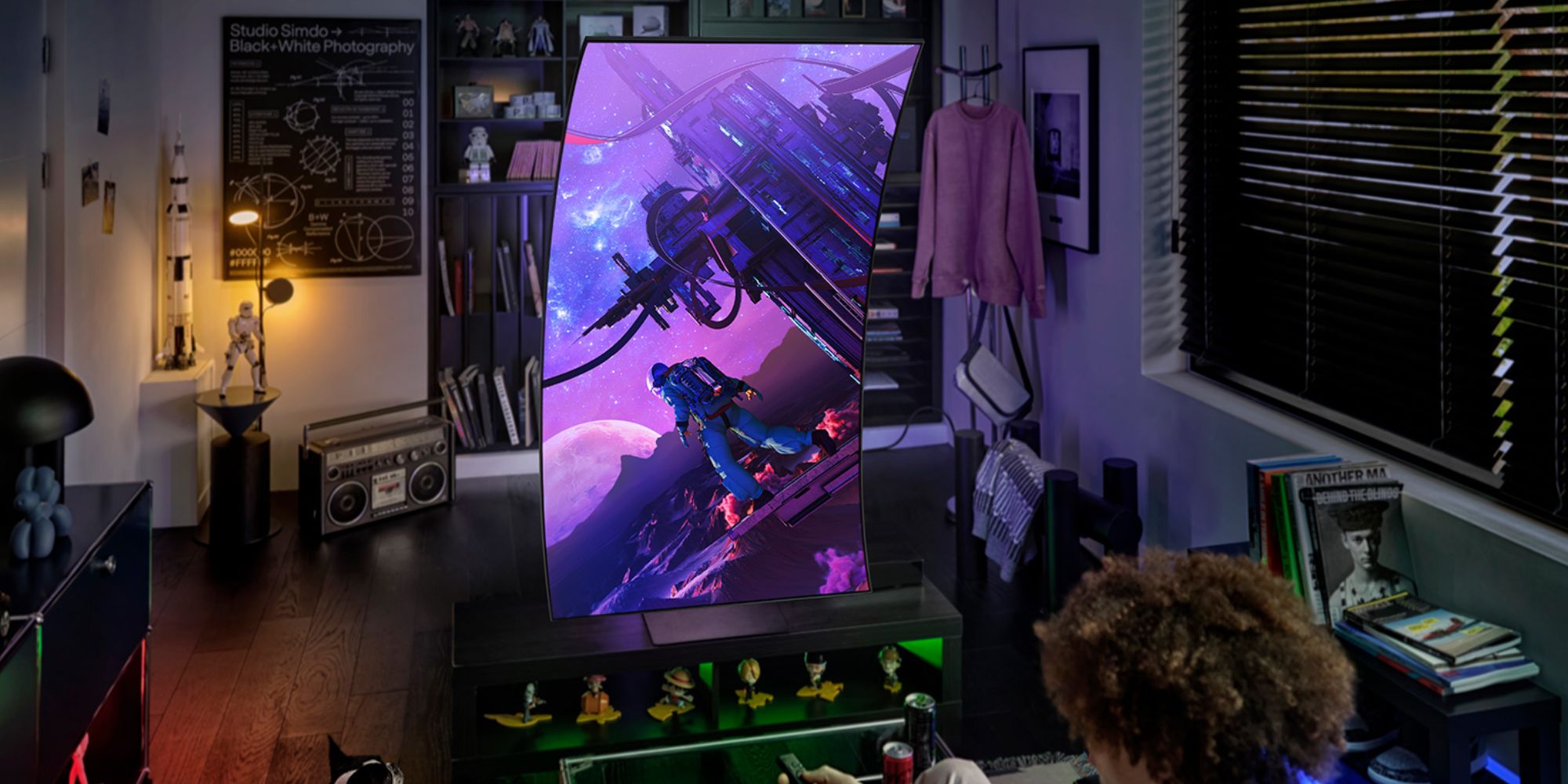 Image showing a person sitting in front of Samsung's Odyssey Ark 2nd-gen gaming monitor.
